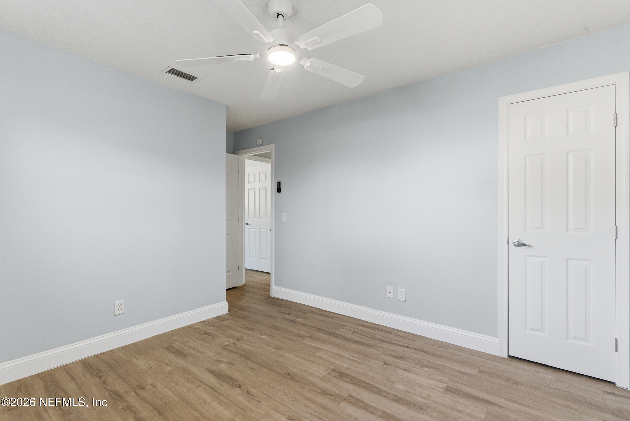 97150 Caravel Trail Yulee, FL 32097 - Photo 29 of 35 an empty room with wooden floor and fan