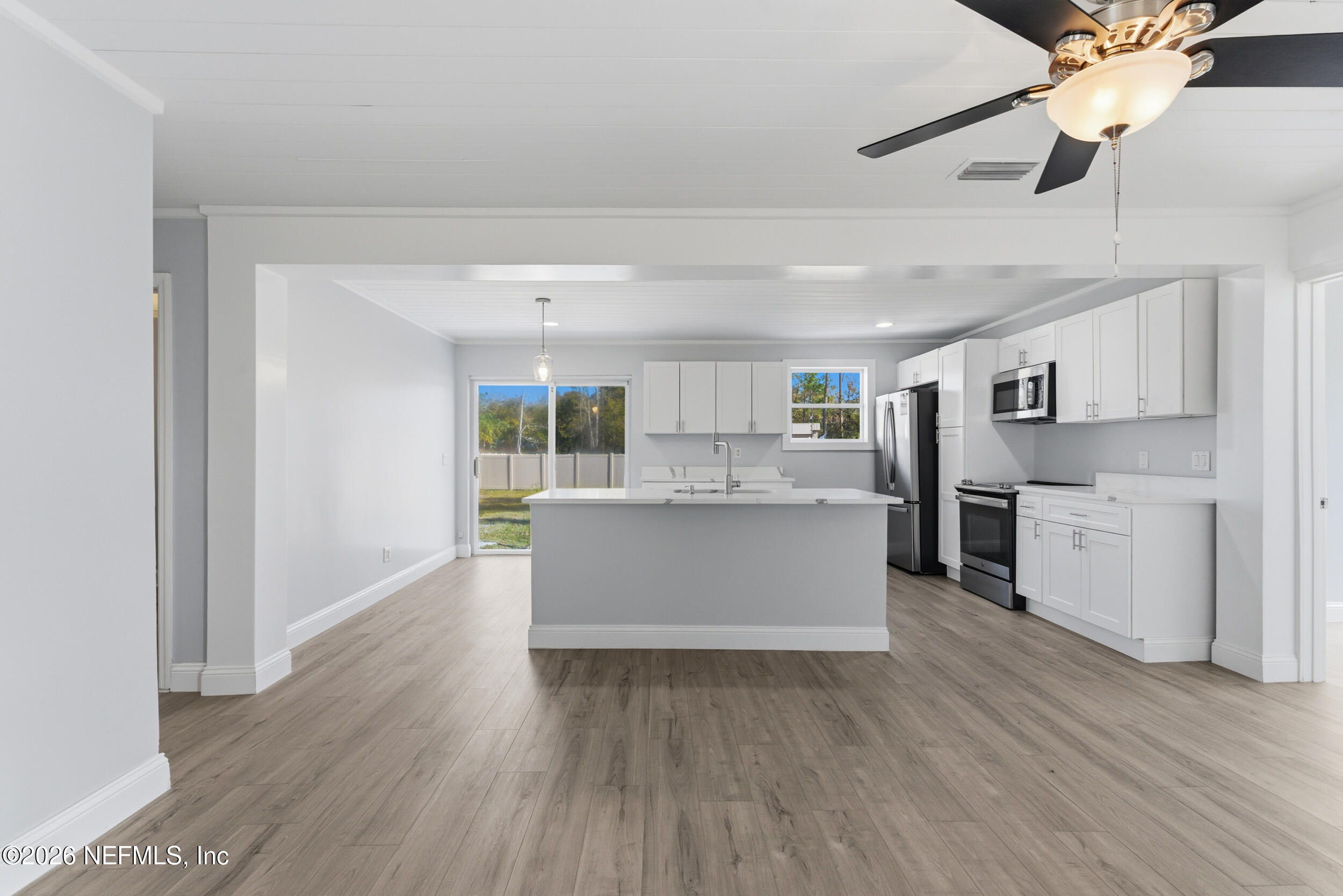 97150 Caravel Trail Yulee, FL 32097 - Photo 6 of 35 a large kitchen with a center island wooden floor and stainless steel appliances