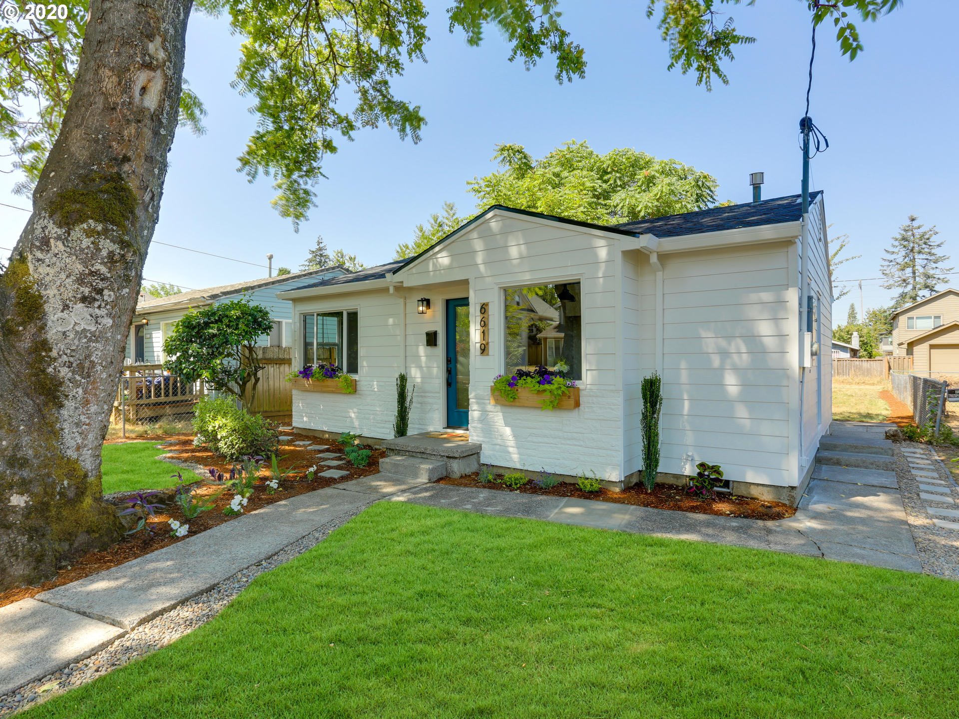 6619 Southeast Knight Street Portland, OR 97206 - Photo 2 of 30 a view of a backyard with table and chairs potted plants and a large tree