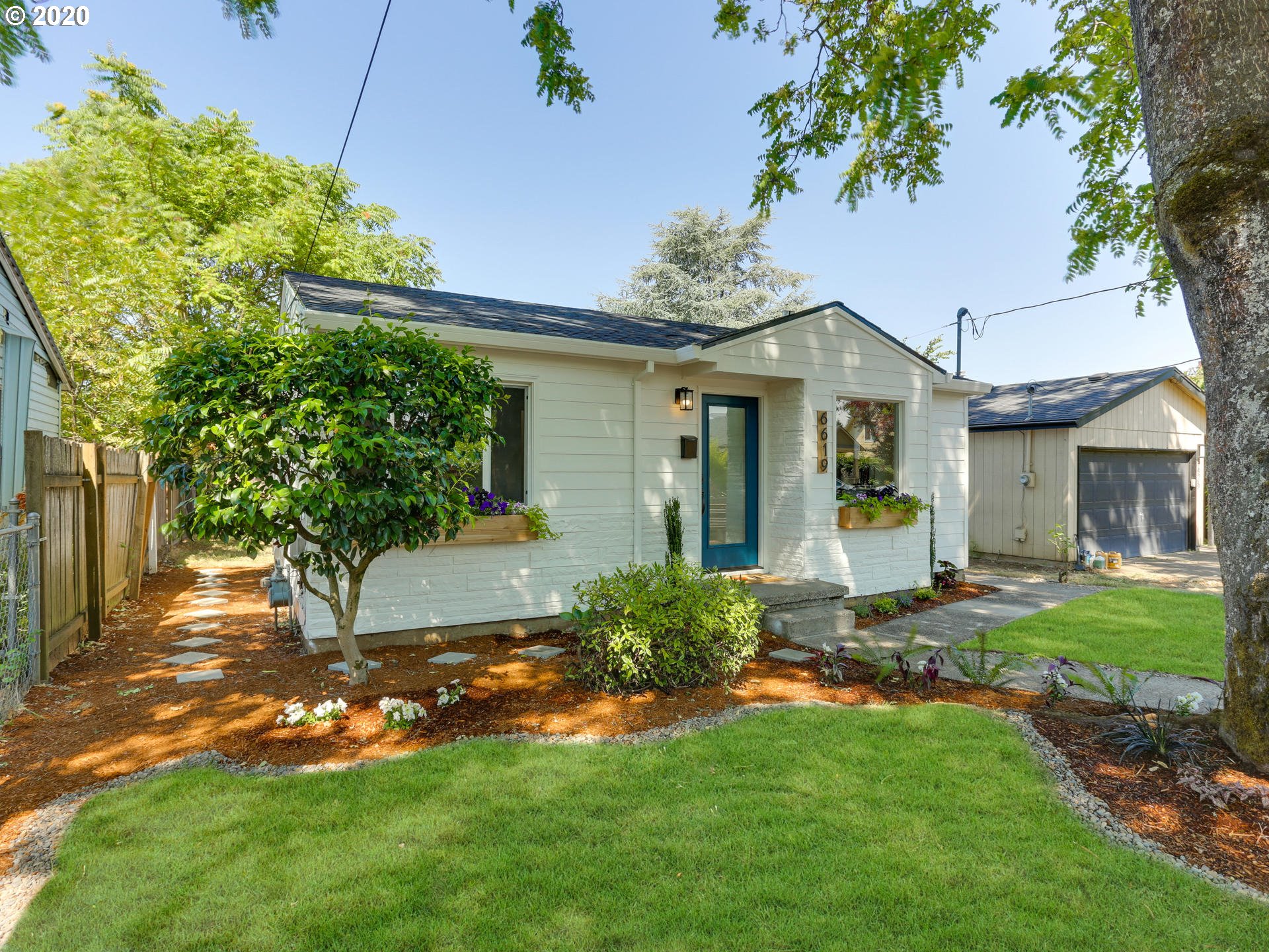6619 Southeast Knight Street Portland, OR 97206 - Photo 4 of 30 a front view of a house with a yard and trees