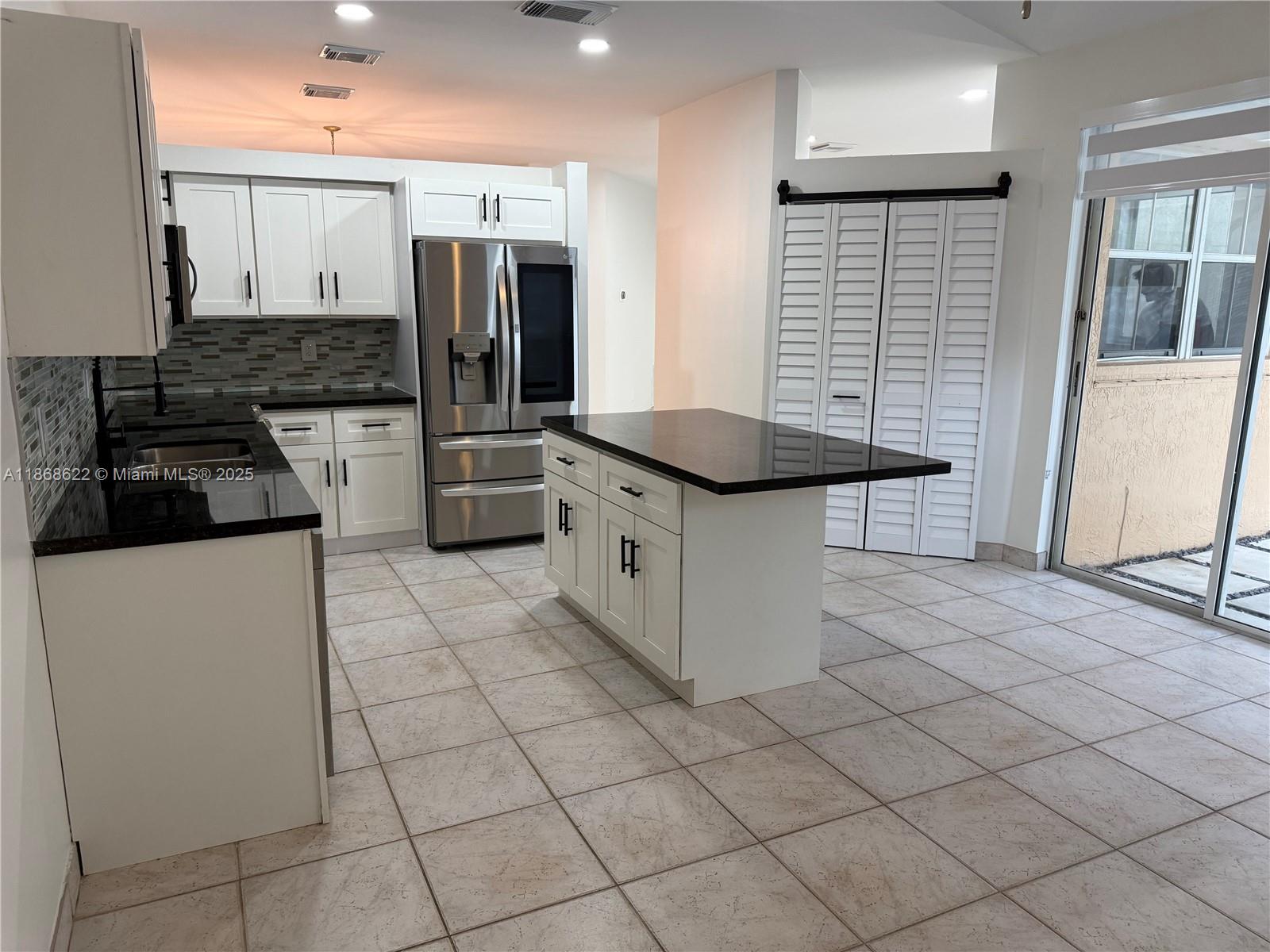 6955 Southwest 148 Lane Davie, FL 33331 - Photo 12 of 22 a kitchen with stainless steel appliances granite countertop a stove a sink and a refrigerator