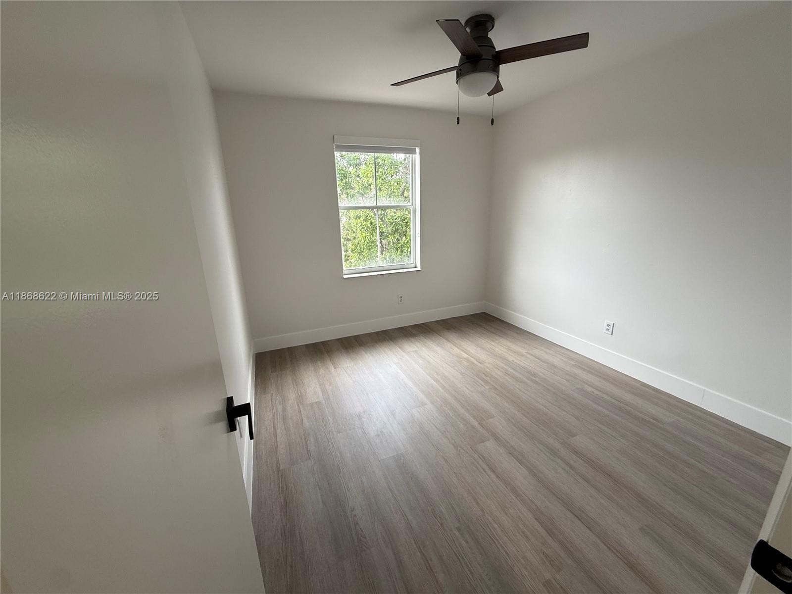 6955 Southwest 148 Lane Davie, FL 33331 - Photo 20 of 22 an empty room with wooden floor fan and windows