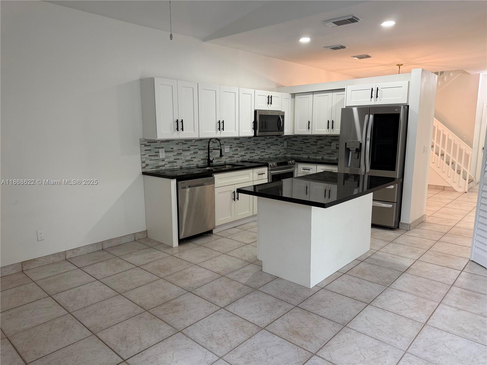 6955 Southwest 148 Lane Davie, FL 33331 - Photo 7 of 22 a kitchen with stainless steel appliances granite countertop a sink and a stove