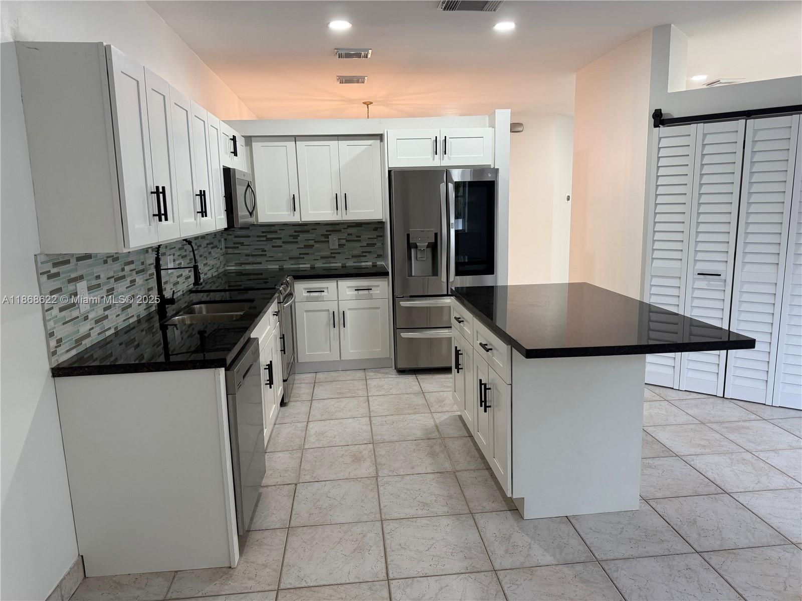 6955 Southwest 148 Lane Davie, FL 33331 - Photo 8 of 22 a kitchen with granite countertop a sink and a stove