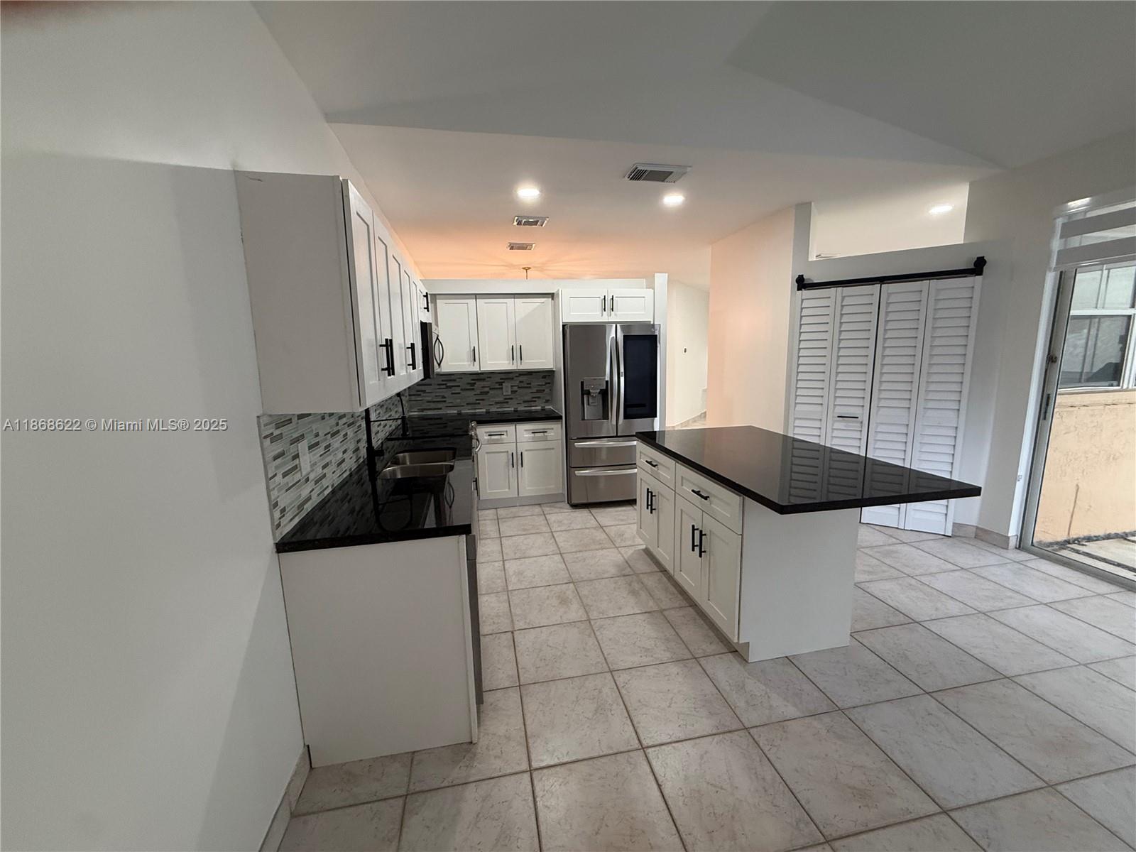 6955 Southwest 148 Lane Davie, FL 33331 - Photo 9 of 22 a kitchen with stainless steel appliances a stove a sink and a refrigerator