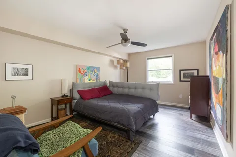a bedroom with a bed and wooden floor