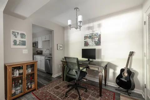 a view of a workspace with furniture and wooden floor