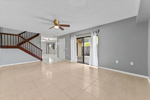 a view of an empty room and chandelier fan