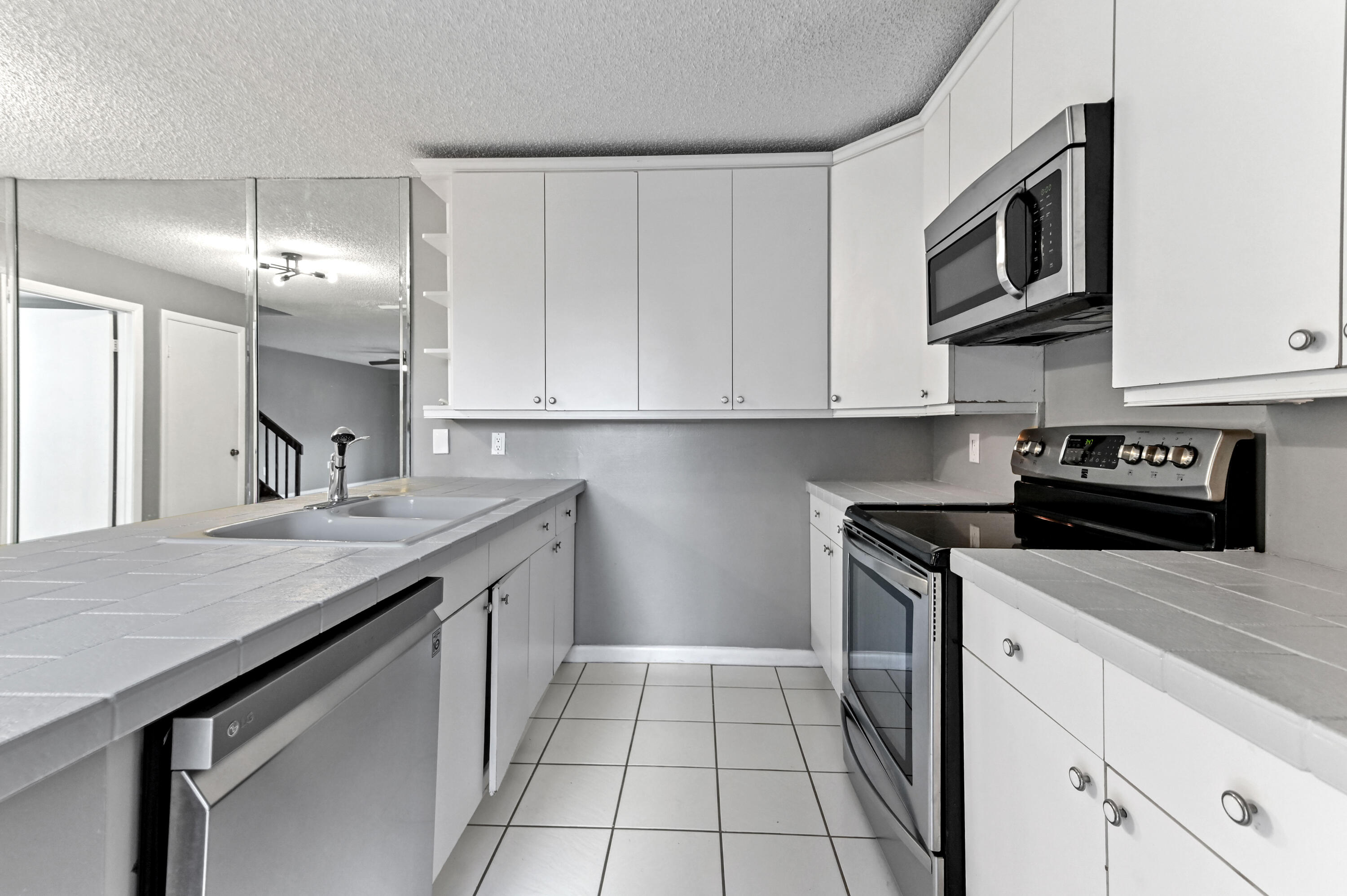 619 6th Way West Palm Beach, FL 33407 - Photo 9 of 24 a kitchen with stainless steel appliances granite countertop a sink stove and cabinets