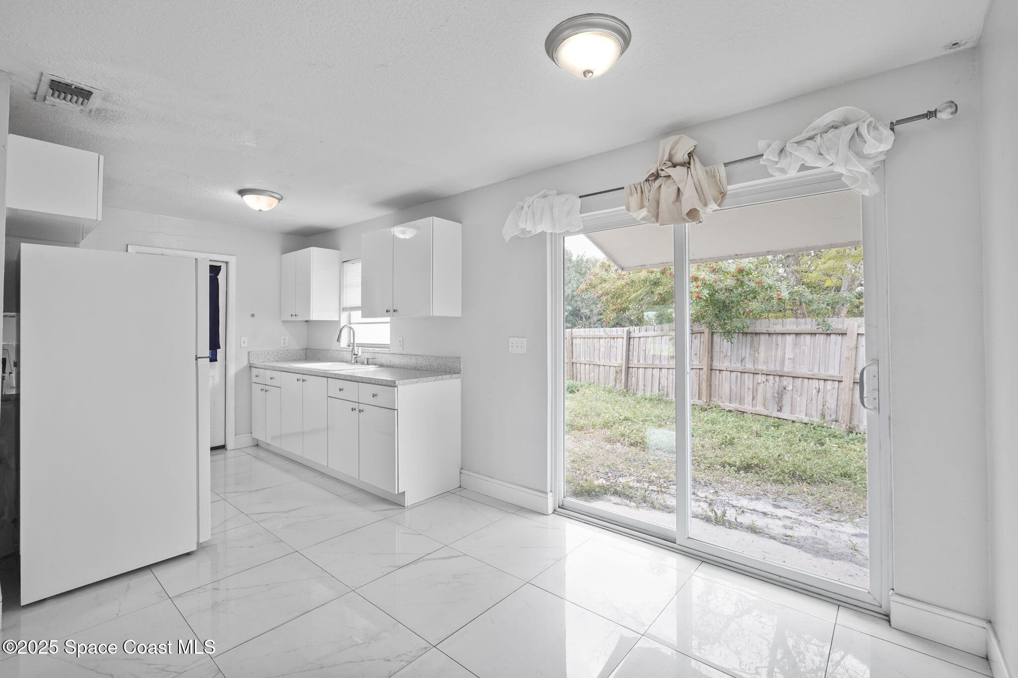 93 Prospect Avenue Cocoa, FL 32922 - Photo 13 of 25 a kitchen with white cabinets and window