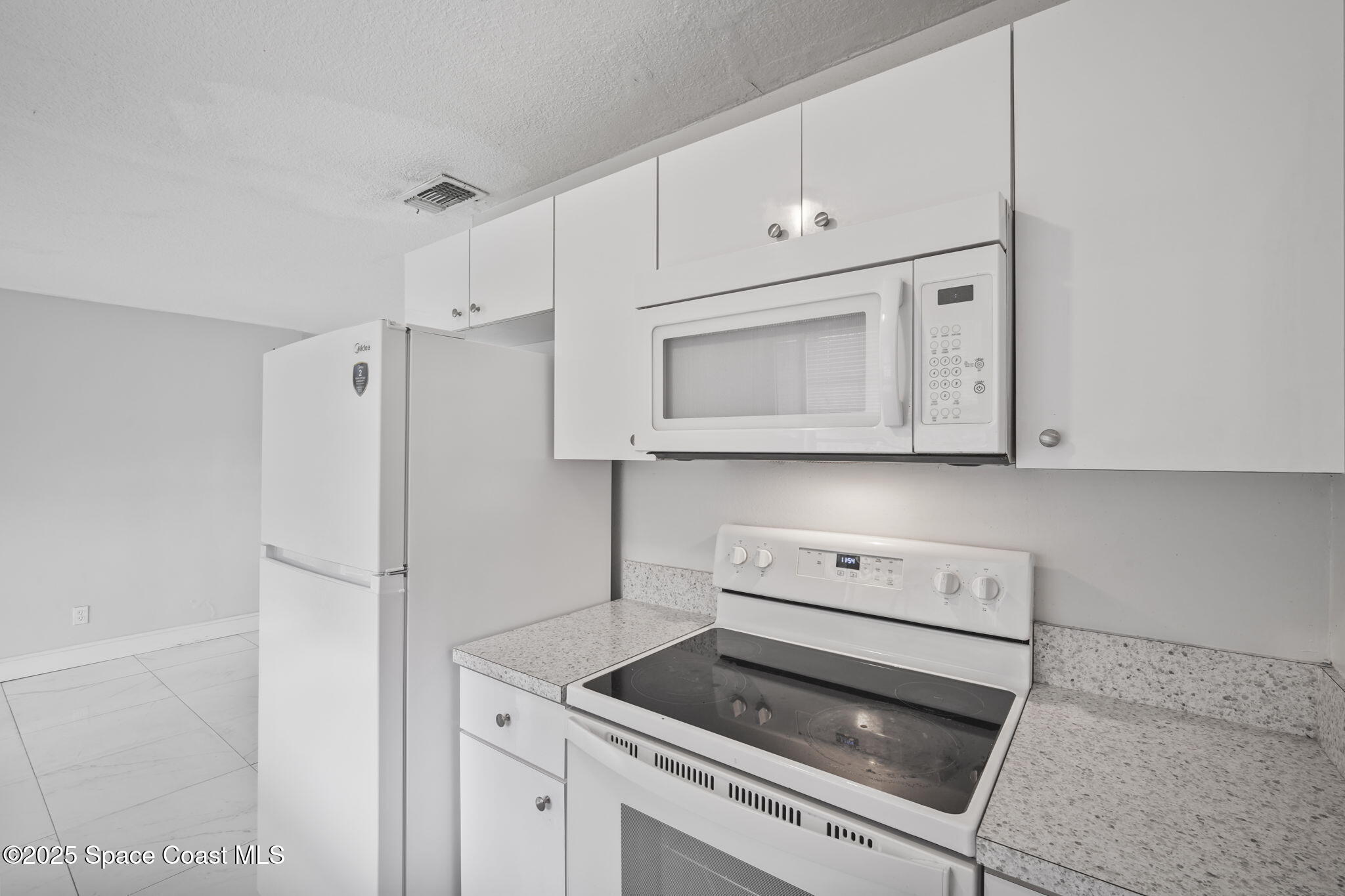 93 Prospect Avenue Cocoa, FL 32922 - Photo 9 of 25 a kitchen with white cabinets and white appliances