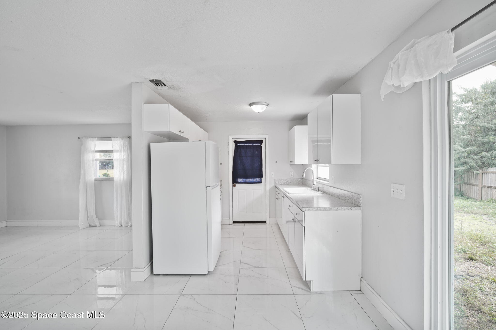 93 Prospect Avenue Cocoa, FL 32922 - Photo 10 of 25 a view of a kitchen with refrigerator and window