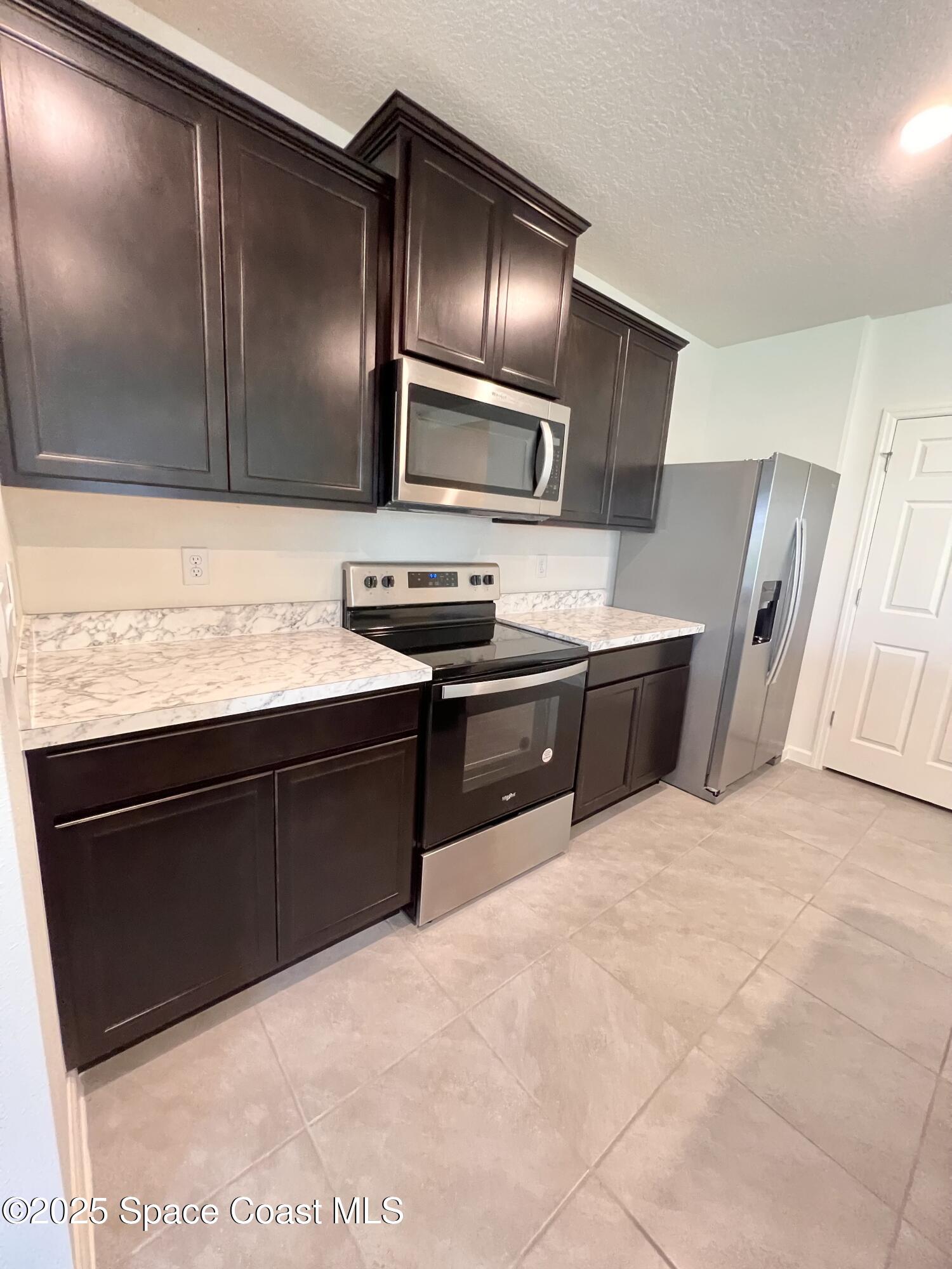 4631 Talbot Boulevard Cocoa, FL 32926 - Photo 11 of 24 a kitchen with stainless steel appliances granite countertop a sink stove and refrigerator