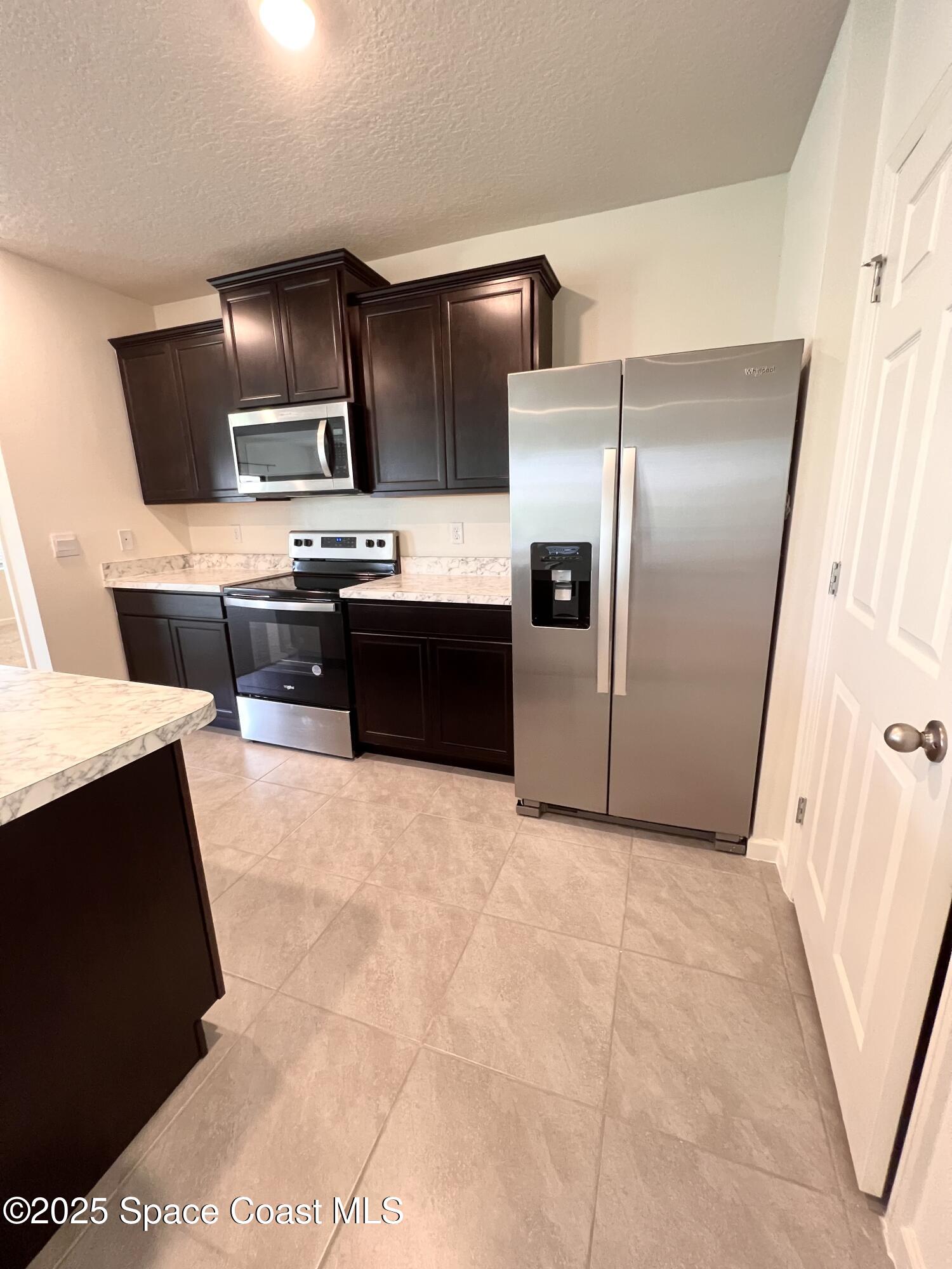 4631 Talbot Boulevard Cocoa, FL 32926 - Photo 13 of 24 a large kitchen with cabinets and stainless steel appliances