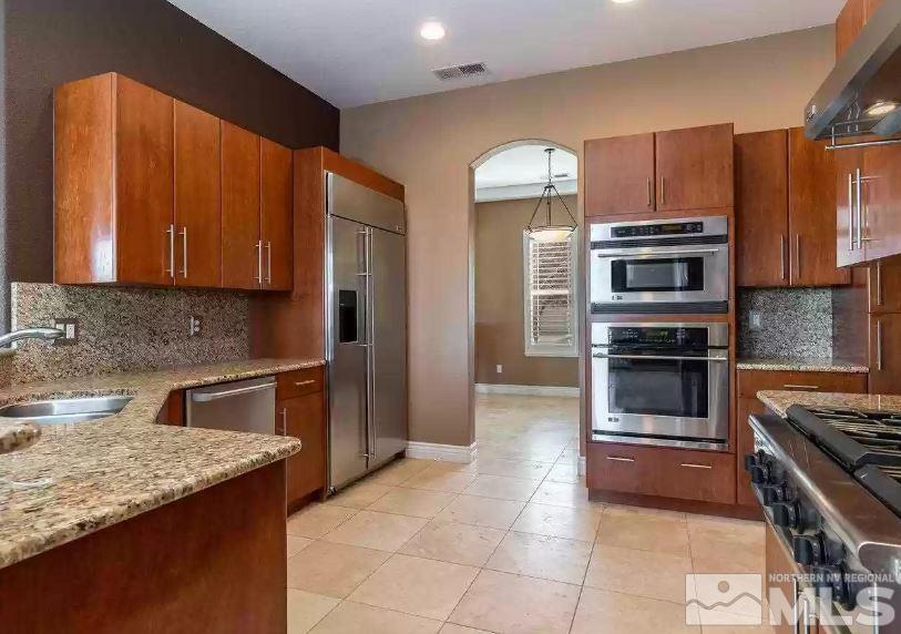 2820 Oxley Drive Sparks, NV 89436 - Photo 10 of 10 a kitchen with granite countertop a stove and a refrigerator