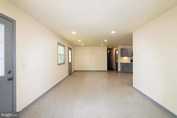 an empty room with windows and fan