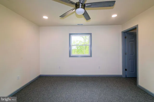an empty room with closet and a chandelier fan