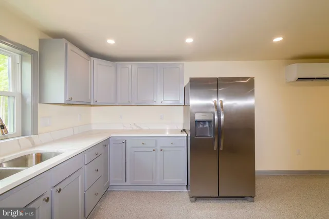 a large kitchen with a stove a sink dishwasher a refrigerator and a microwave