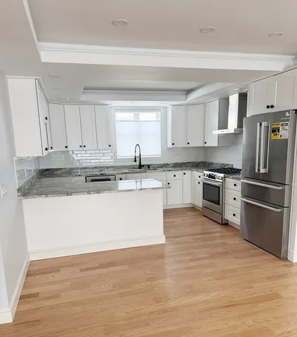 a large kitchen with stainless steel appliances granite countertop a stove a sink dishwasher and a refrigerator