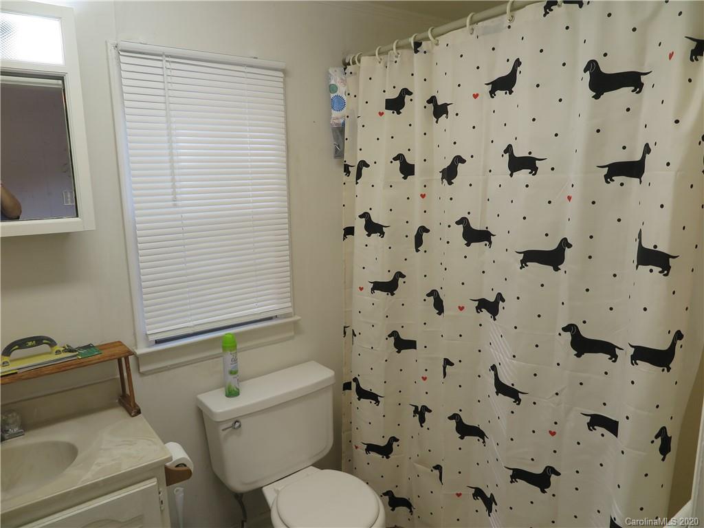 515 Upper Spencer Mountain Road Stanley, NC 28164 - Photo 15 of 28 a white toilet sitting next to a shower curtain