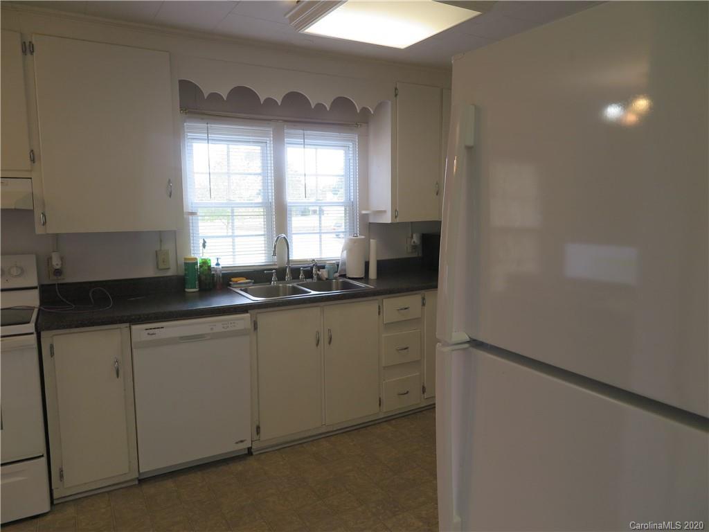 515 Upper Spencer Mountain Road Stanley, NC 28164 - Photo 19 of 28 a kitchen with granite countertop white cabinets and white appliances
