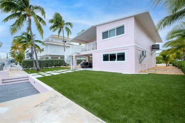 a front view of a house with a yard and potted plants