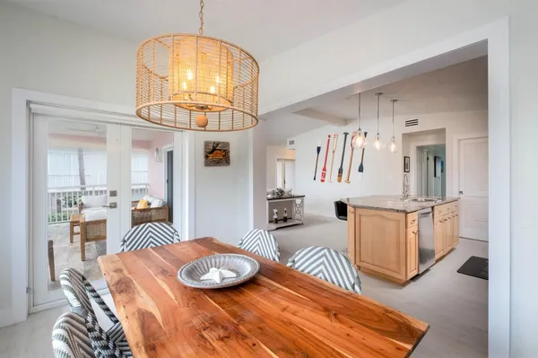 a large kitchen with kitchen island granite countertop a stove a sink a dining table and chairs