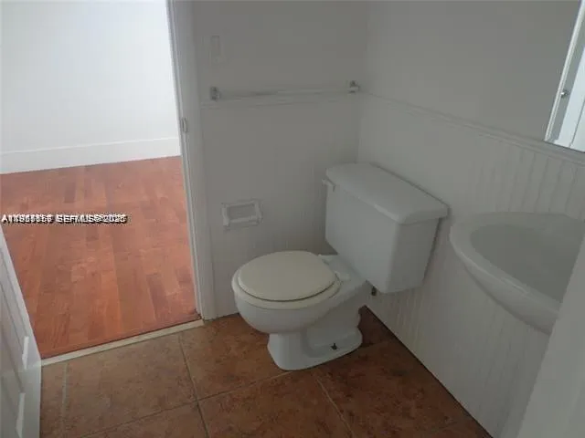 a white toilet sitting next to a shower