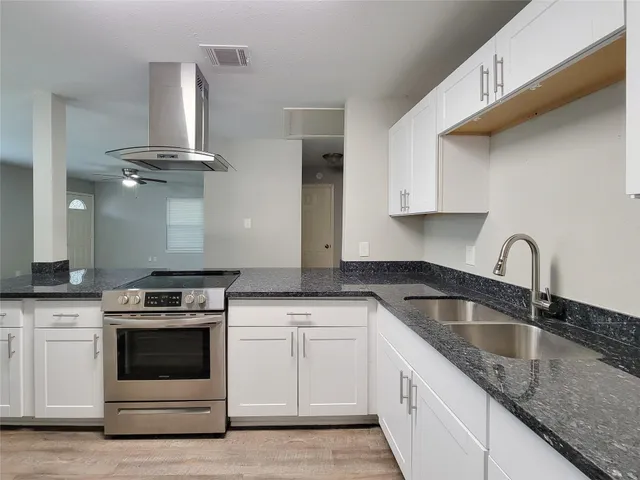 a kitchen with granite countertop a sink stainless steel appliances and cabinets