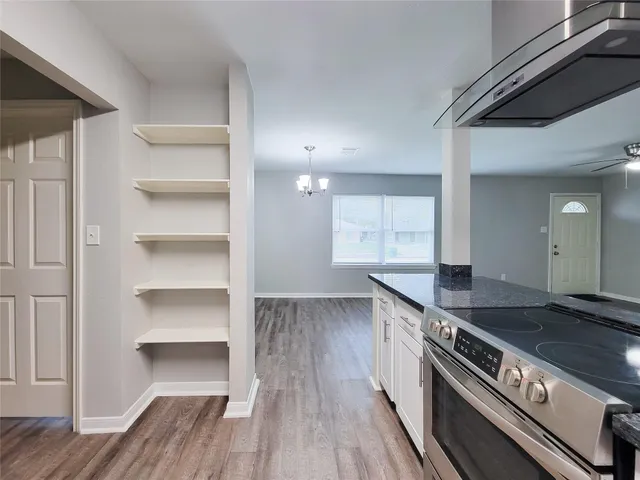 a kitchen with granite countertop a stove and cabinets