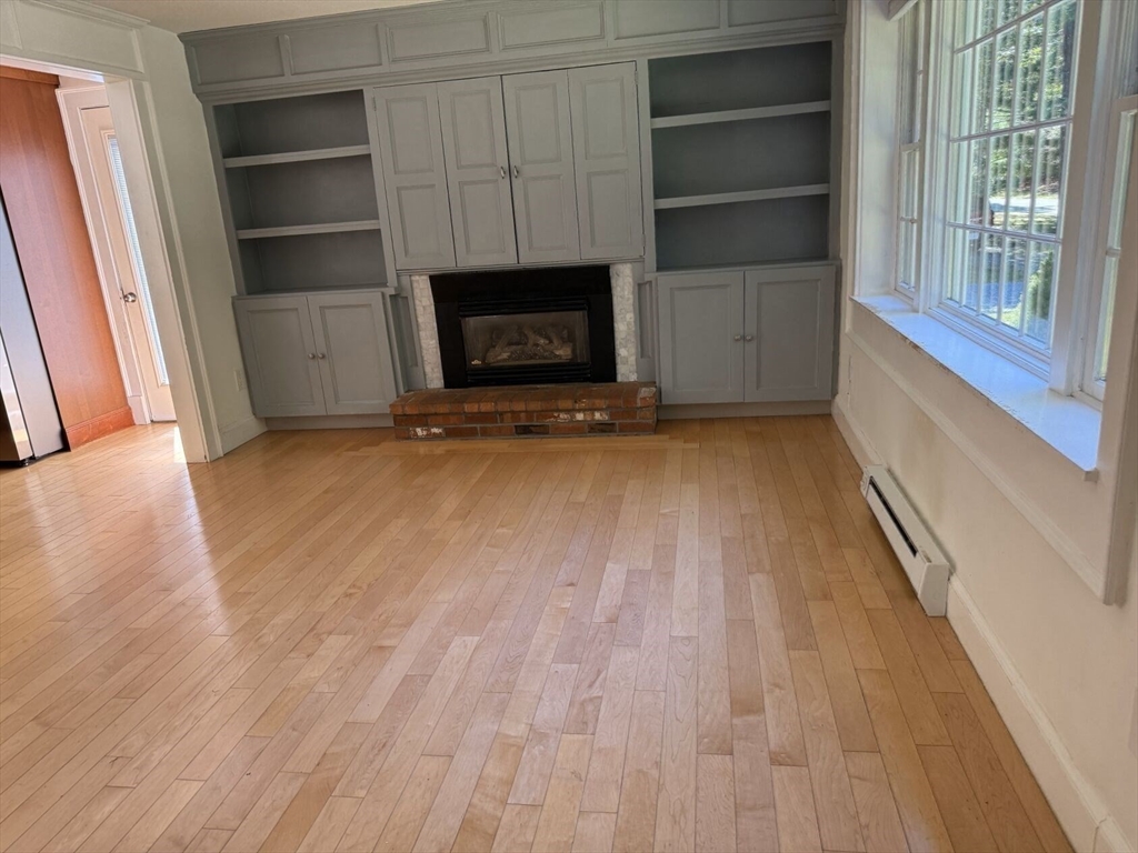 526 Skunknet Road Barnstable, MA 02632 - Photo 15 of 20 a view of an empty room with a fireplace and a window