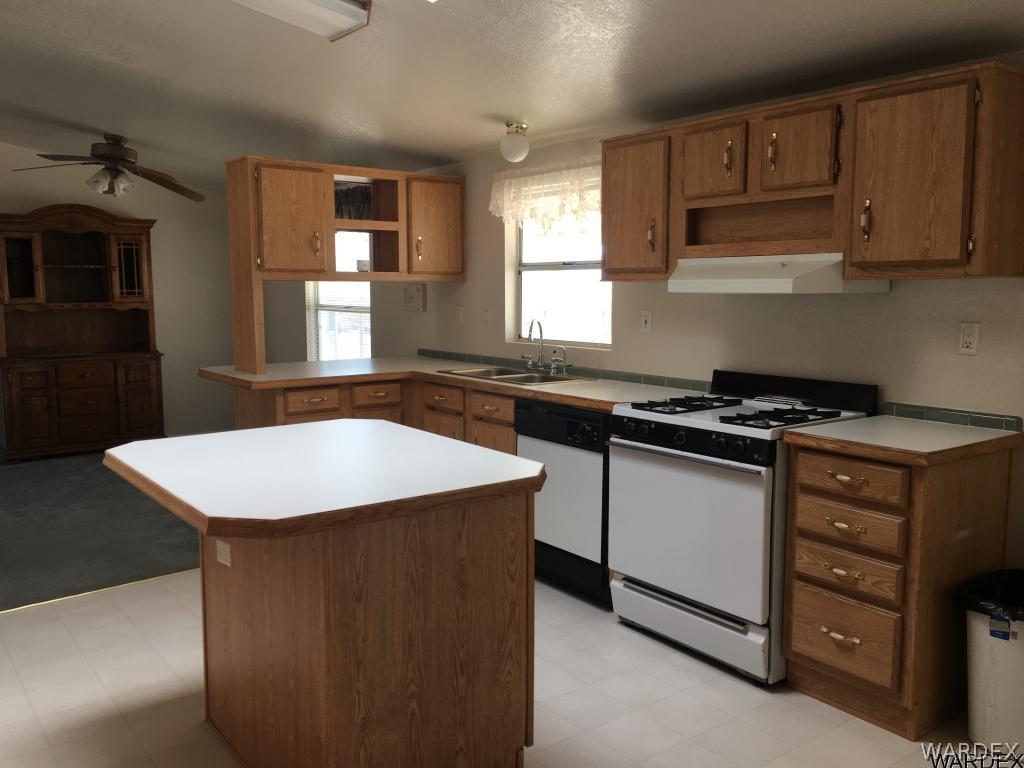 3192 Keystone Road Golden Valley, AZ 86413 - Photo 26 of 36 a kitchen with granite countertop a sink a stove and cabinets
