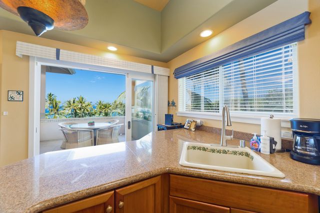 a kitchen with kitchen island a counter top space and living area
