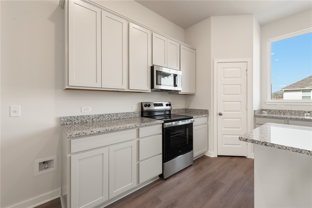 2220 Amber Court Bryan, TX 77807 - Photo 19 of 35 a kitchen with granite countertop white cabinets and a stove