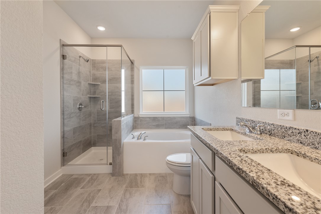 2220 Amber Court Bryan, TX 77807 - Photo 25 of 35 a bathroom with a granite countertop sink a toilet and bathtub