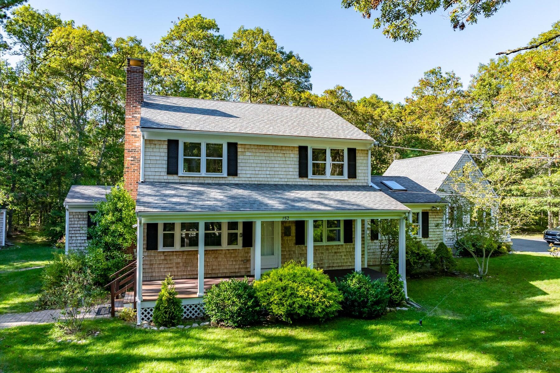 152 Wakeby Road Marstons Mills, MA 02648 - Photo 2 of 27 a view of a brick house with a big yard plants and large trees