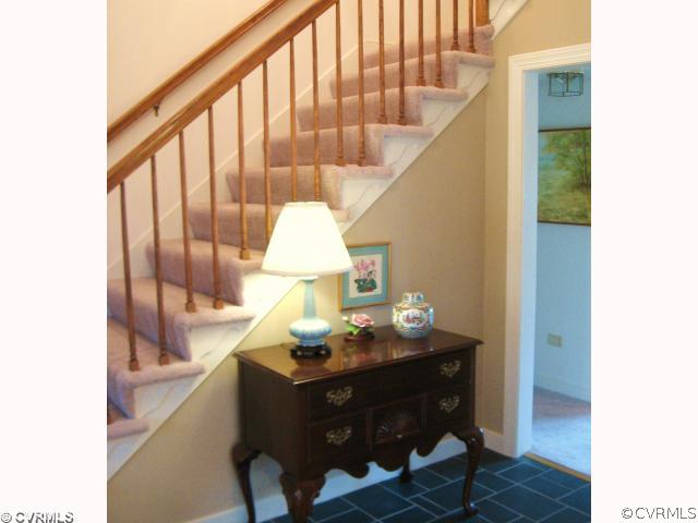 5841 Deep Forest Road Chester, VA 23831 - Photo 2 of 12 a view of a hallway with a dining table and chandelier