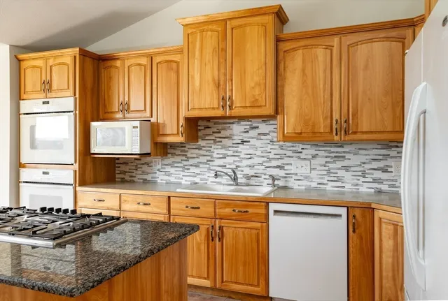 a kitchen with granite countertop cabinets and stove