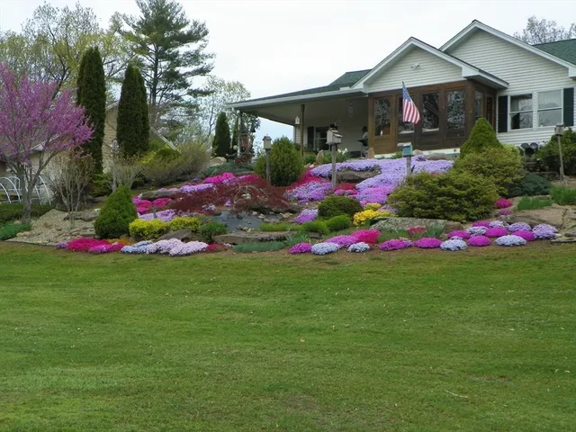 a view of a house with a big yard and potted plants