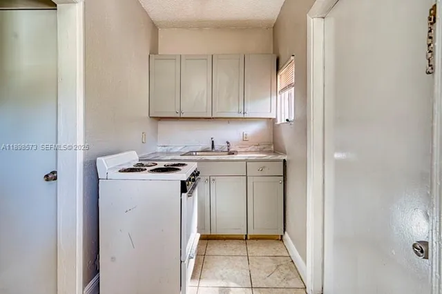 a kitchen with white cabinets and white appliances