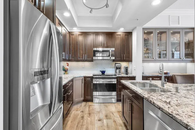 a kitchen with stainless steel appliances granite countertop a sink stove and refrigerator