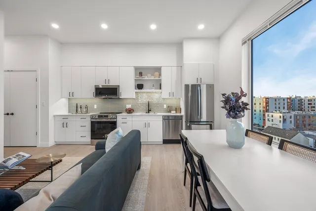 a kitchen with stainless steel appliances granite countertop a sink refrigerator and cabinets