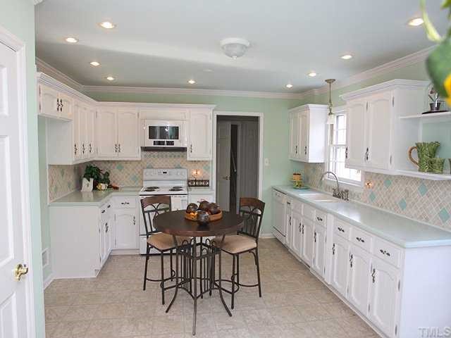 6808 Garrison Court Raleigh, NC 27613 - Photo 8 of 20 The kitchen has a new floor, solid surface counter tops and tumbled marble and glass backsplash.