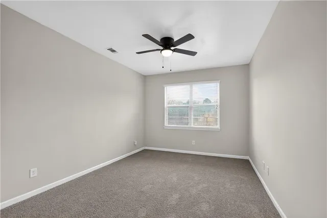 an empty room with a window and a ceiling fan