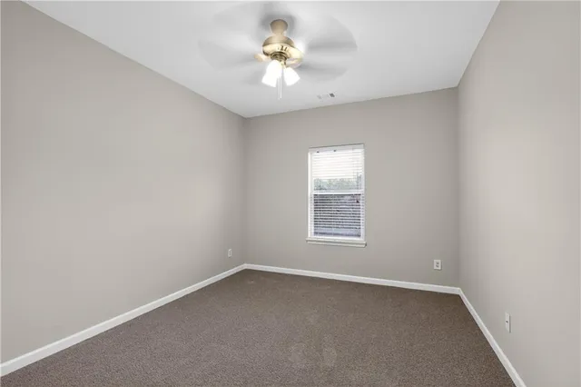 an empty room with a window and a ceiling fan