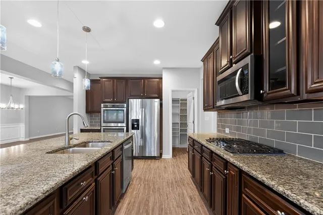 a kitchen with stainless steel appliances granite countertop a sink stove and refrigerator