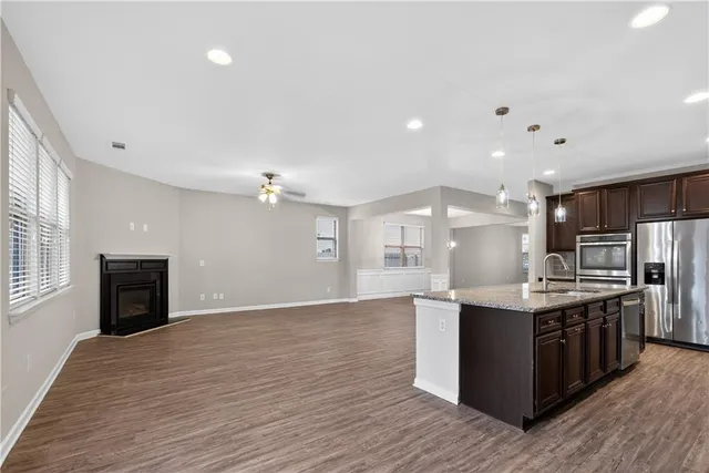 a kitchen with stainless steel appliances granite countertop a sink stove and refrigerator