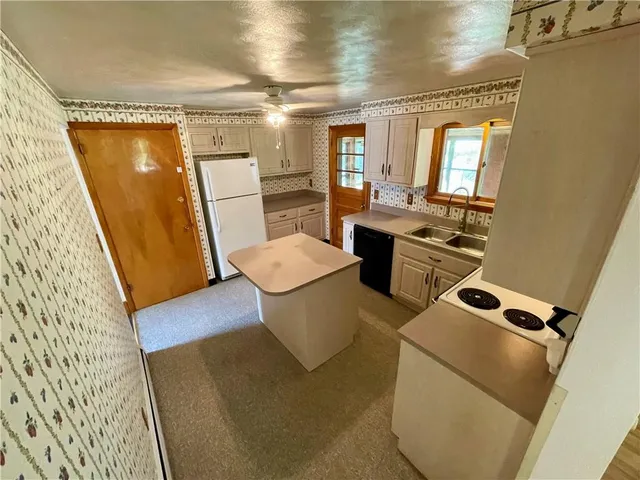 a view of kitchen with sink and refrigerator