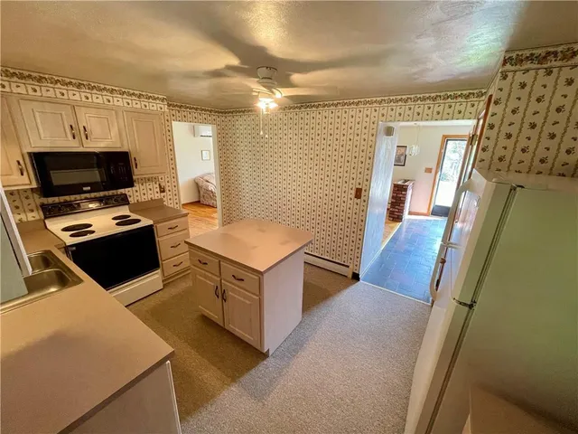 a view of kitchen with sink microwave and refrigerator