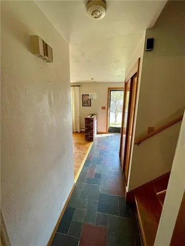 a view of a hallway with wooden floor and furniture